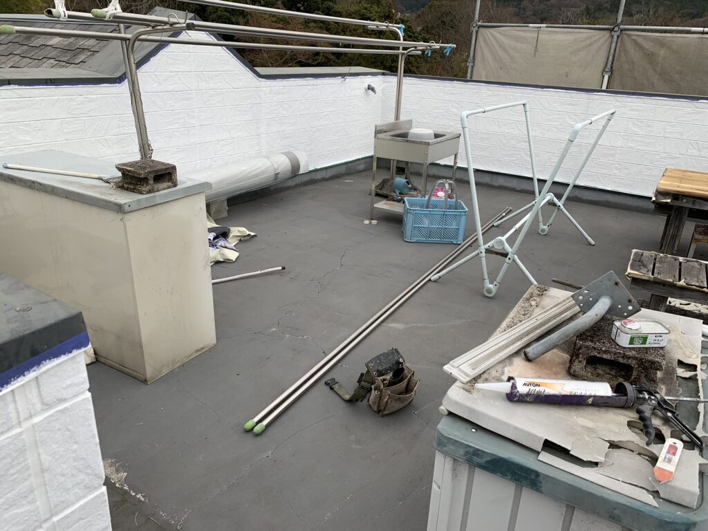 「屋上の既存ウレタン防水が劣化し、ひび割れや汚れが目立つ施工前の状態」